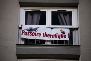 Une banderole accrochée à une fenêtre dénonce un problème d’isolation thermique dans un logement HLM de la ville de Paris. 