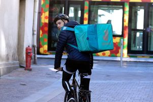 Un coursier à vélo qui travaille pour Deliveroo livre un repas dans le centre ville de Montpellier. 
