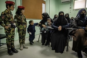 A Kaboul, le 17 novembre 2022, des femmes afghanes assises face à deux garçons habillés en soldats.