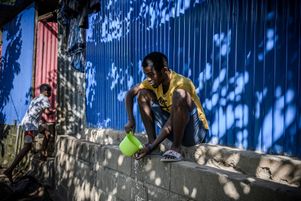 Le 27 mai 2023, un jeune homme se brosse les dents dans la rue, près du bidonville dit de « Talus 2 » à Mayotte.
