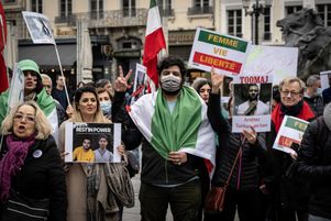 Des manifestants portant le portrait du rappeur Toomaj Salehi (à droite) lors d’un rassemblement le 8 janvier 2023 à Lyon.