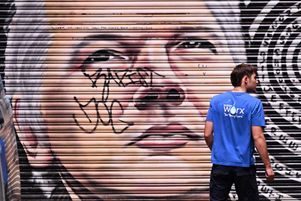 Un homme passe devant une fresque du fondateur de WikiLeaks, Julian Assange, à Melbourne (Australie), le 26 mars 2024.