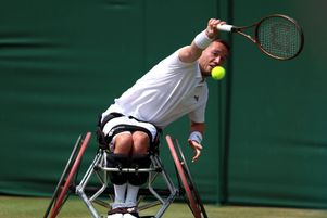 Le britannique Alfie Hewett joue un coup droit contre l’athlète français Stephane Houdet le 11 juillet 2024 dans un match du simple en fauteuil roulant aux Championnats de Wimbledon à Londres.