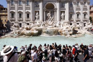 Des personnes se rafraîchissent à la fontaine de Trevi au cours d’une journée étouffante à Rome le 29 juillet 2024.