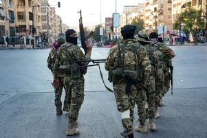  Des combattants rebelles patrouillent dans le centre d’Alep, le 30 novembre 2024.