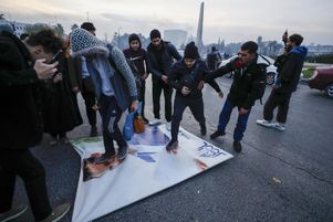 Des Syriens célèbrent l’arrivée des combattants de l’opposition en marchant sur un portrait de Bachar Al Assad, à Damas (Syrie), le 8 décembre 2024.
