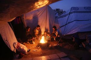 Des Palestiniens se rassemblent autour d’un feu pour se réchauffer, à Jabaliya, dans le nord de la bande de Gaza, le 10 mars 2025.