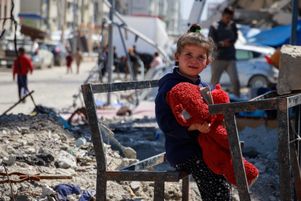 Entre les décombres, sur un pupitre d’école incendié, une petite fille joue avec sa poupée, à l’ouest de la ville de Gaza, le lundi 24 mars 2025.