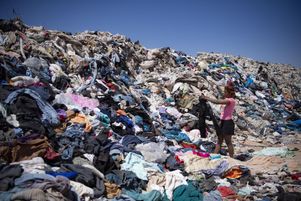 Des femmes recherchent des vêtements usagés parmi des tonnes de déchets jetés dans le désert d’Atacama, à Alto Hospicio, Iquique, Chili, le 26 septembre 2021.