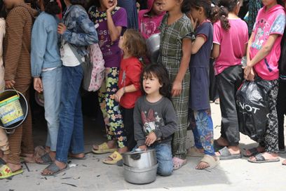 Des enfants palestiniens font la queue pour recevoir un repas distribué par une organisation caritative à Gaza, jeudi 15 mai 2025.
