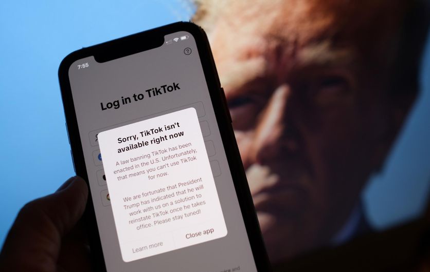 Téléphone affichant un message en cas de tentative de connexion à TikTok aux États-Unis, devant une photo du président américain élu Donald Trump, le 18 janvier 2025 à Washington