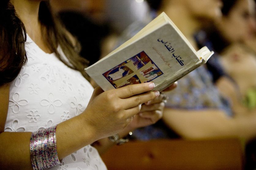 10 Septembre, 2012: Une fidèle lit l'évangile pendant la messe de semaine en l'église Notre-Dame, Hadath, Liban.